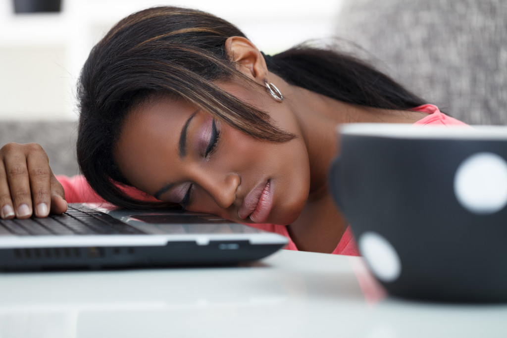 Young women sleeping with her head on a laptop