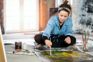 Young woman as artist at her studio - image womanpainting-300x200 on https://thedreamcatch.com