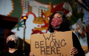 Image: Narasaki holds a cardboard sign during a protest against anti-Asian hate crimes in Seattle - image belong-300x189 on https://thedreamcatch.com