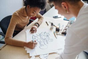 Young multiethnic couple working together in their studio practicing lettering - image woman-writing-300x200 on https://thedreamcatch.com